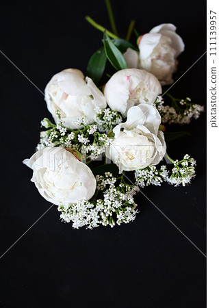 Fresh white peonies on a black, dark background. A condolence card. Wedding date. An invitation to a holiday. Congratulation.An empty space for text. View from above. He was lying flat. Fresh white peonies on a black, dark background. A condolence card. Wedding date. An invitation to a holiday. Congratulation.An empty space for text. View from above. He was lying flat. 111139957
