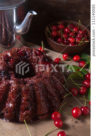 Delicious chocolate cake with sweet cherry and vintage kettle on dark wooden background.. 111140080