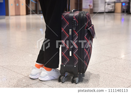 Faceless girl in green coat holds passport with ticket and yellow suitcase airport. Airplane travel concept. Faceless girl in green coat holds passport with ticket and yellow suitcase airport. Airplane travel concept. 111140113