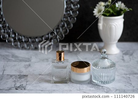 夜間護膚圖像，帶有圓形鏡子以及放置在大理石表面上的精華液和乳霜 111140726