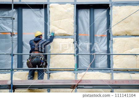 AI-generated content. Worker applies insulation with glass wool for energy saving on a new construction site. Generative AI 111141104