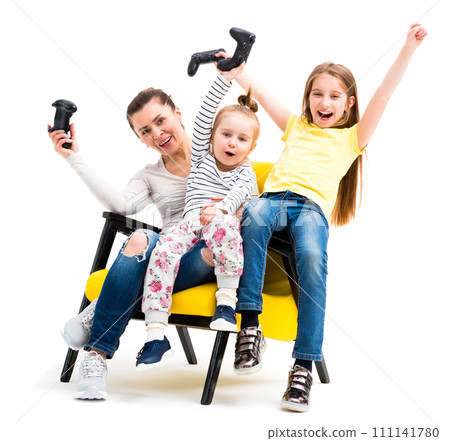 Mother and two daughters playing games with joystick, winning and being happy and cheerful Mother and two daughters playing games with joystick, winning and being happy and cheerful 111141780