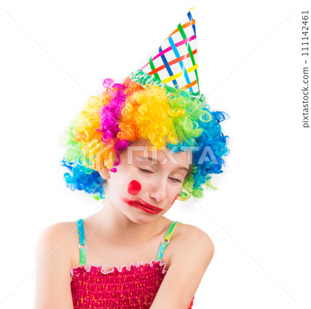 Upset little girl in clown wig and smeared make up isolated on white background 111142461