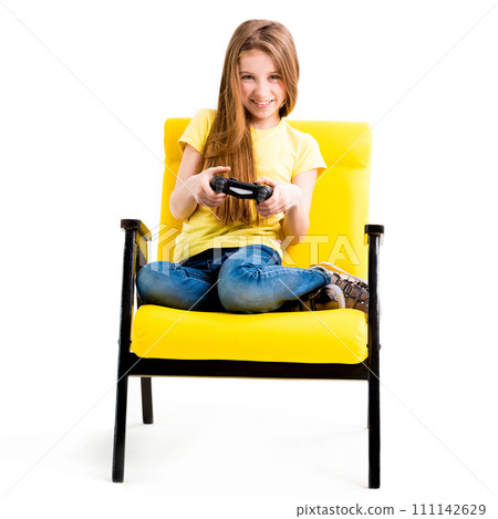Pretty teen girl sitting, holding black joystick, playing console for computer games 111142629