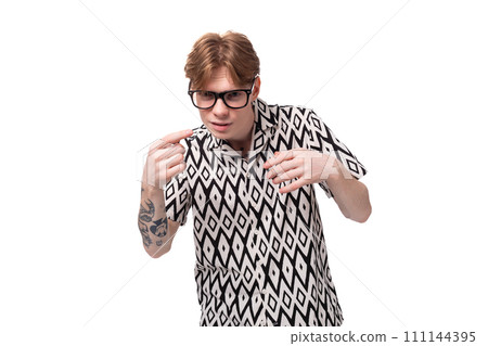 a young caucasian guy with red hair dressed in a shirt squints because of poor eyesight a young caucasian guy with red hair dressed in a shirt squints because of poor eyesight 111144395