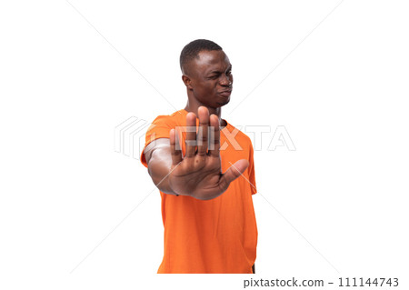 young american man dressed in orange corporate t-shirt showing refusal and disagree gesture 111144743
