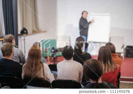 Engaged audience attentively listening to a speaker at a professional workshop event 111145076