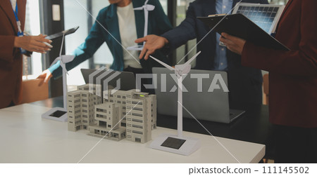 Close-up at tablet, Engineers pointing at tablet with their hands. To jointly design the use of renewable energy with wind and solar energy. Concept of using renewable energy. 111145502