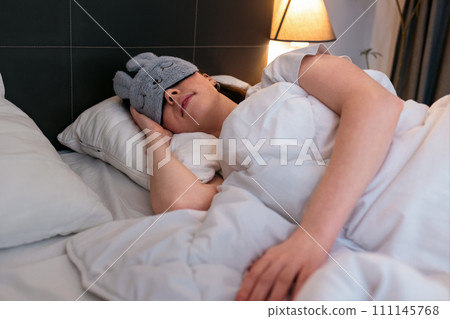 Caucasian woman wearing mask is fast asleep in her bed. Concept of insomnia and well sleeping with medicines 111145768