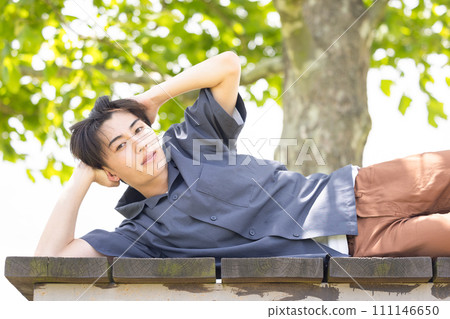 man lying on a bench 111146650