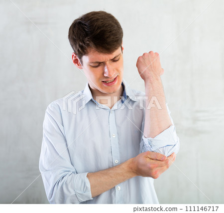 Man experiencing acute pain in his elbow Man experiencing acute pain in his elbow 111146717