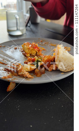 A plate with the remains of an eaten dinner A plate with the remains of an eaten dinner 111147264
