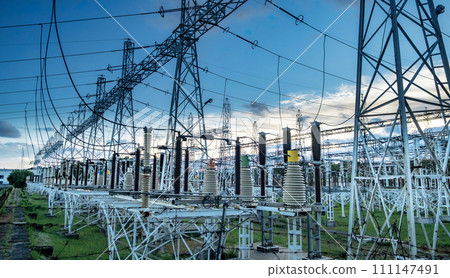 High voltage power transformer substation before russian bombed on Ukraine territory. High voltage tower with blue sky and sunset. High voltage power transformer substation before russian bombed on Ukraine territory. High voltage tower with blue sky and sunset. 111147491