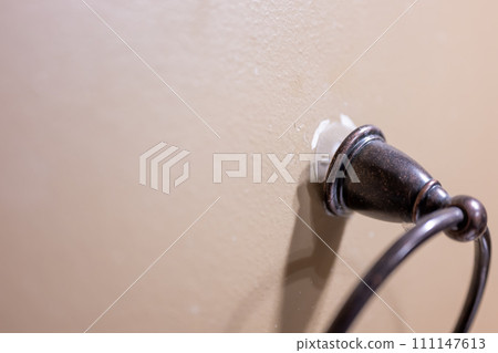Wall fixture being pulled out of drywall because of a bad installation. Wall fixture being pulled out of drywall because of a bad installation. 111147613