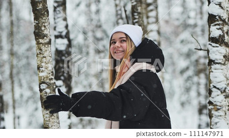 A girl walking in the forest in winter among the birches. A girl walking in the forest in winter among the birches. 111147971