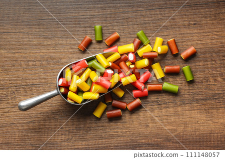 Colorful sweet jelly candies in scoop on wooden table. Top view. Colorful sweet jelly candies in scoop on wooden table. Top view. 111148057
