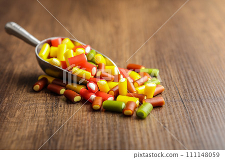 Colorful sweet jelly candies in scoop on wooden table. Colorful sweet jelly candies in scoop on wooden table. 111148059