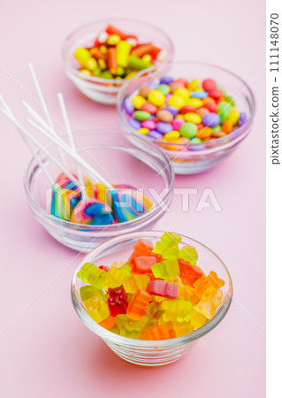 Colorful sweet jelly candies in bowl on pink background. Colorful sweet jelly candies in bowl on pink background. 111148070
