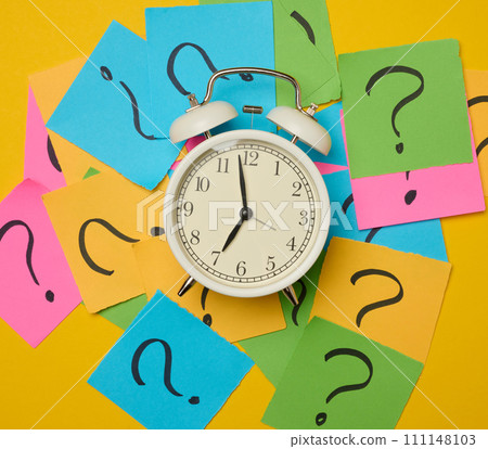 A round alarm clock amidst paper stickers featuring drawn question marks, symbolizing the concepts of truth-seeking and deadlines. 111148103