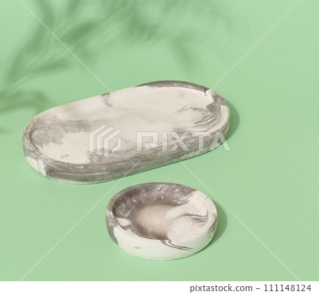 Empty round white marble stand on a green background, a place to display cosmetics and products 111148124