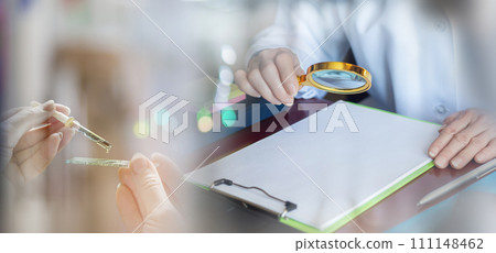 A doctor examines documents with a magnifying glass. A doctor examines documents with a magnifying glass. 111148462