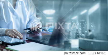 A doctor is sitting at a table in a modern office . A doctor is sitting at a table in a modern office . 111148463