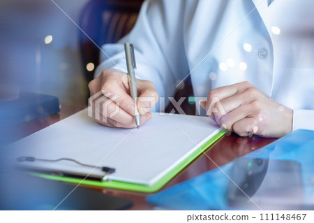 Doctor filling out a health insurance form. 111148467