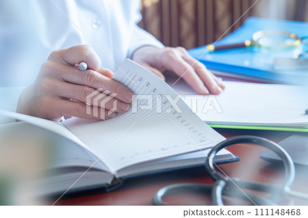 Doctor works with documents at a desk. 111148468