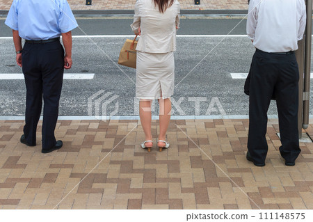 1 woman and 2 men waiting for the bus at the bus stop 111148575