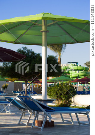 Sun loungers for relaxing by the pool in a water park under an umbrella from the bright sun on vacation in Egypt 111148832