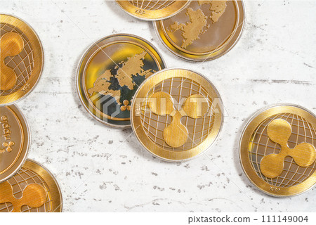Top down view - golden XRP - ripple cryptocurrency - coins on white stone board Top down view - golden XRP - ripple cryptocurrency - coins on white stone board 111149004