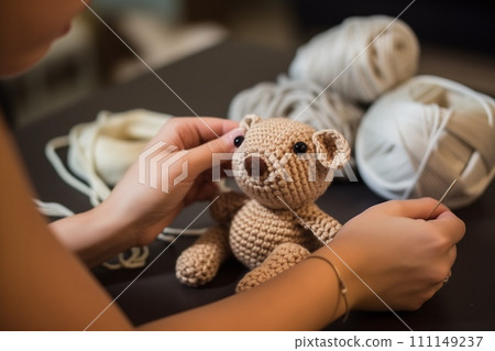 Close up view of hands crocheting a toy teddy bear. AI Generative 111149237