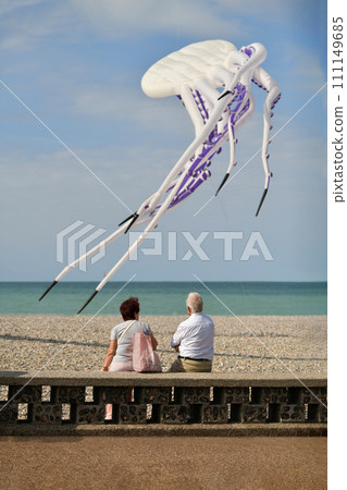 Elderly couple looking at white octopus kites in the sky Kite festival. 111149685