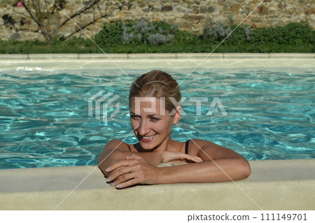 Blonde woman smiling near the pool 111149701