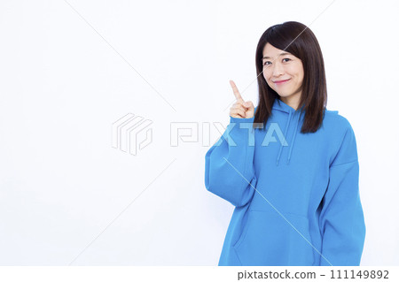 A woman in her 40s wearing a hoodie pointing A woman in her 40s wearing a hoodie pointing 111149892