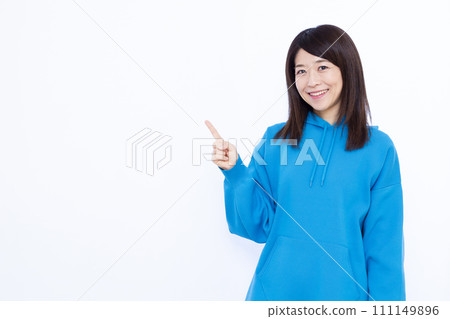 A woman in her 40s wearing a hoodie pointing A woman in her 40s wearing a hoodie pointing 111149896