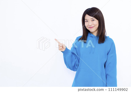 A woman in her 40s wearing a hoodie pointing 111149902
