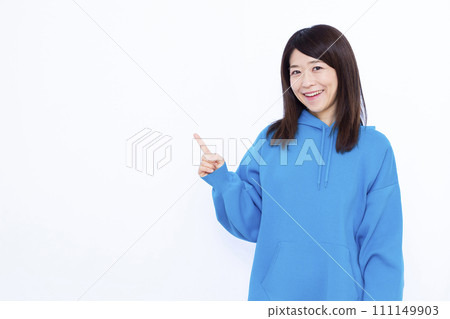 一名 40 多歲、身穿連帽衫的女士指著 111149903