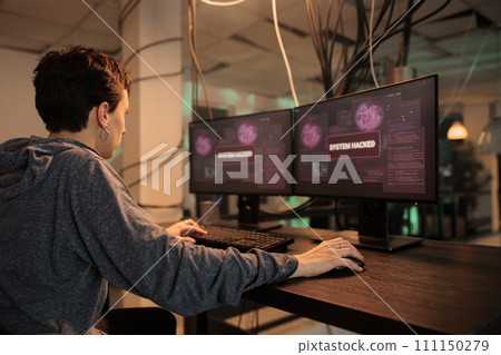 Female spy hacking computer system with trojan virus, stealing privacy data and creating malware. Young hacker coding malicious software and breaking into government database. Back view. 111150279