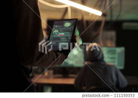 Thief reading access denied message on tablet, hacker failing to crack firewall encrytion and steal data. Internet criminal using malicious software, to break and crack passwords. 111150353