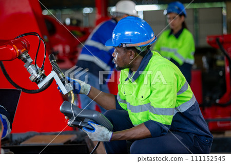 Male american african technician holding remote control automation robotics at industrial modern. 111152545
