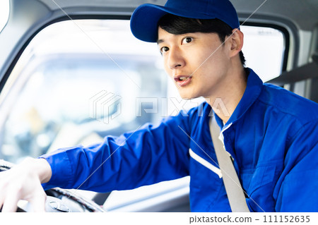 Young courier driving a truck 111152635
