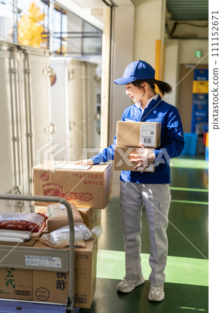 Female worker working in a distribution warehouse Female worker working in a distribution warehouse 111152671