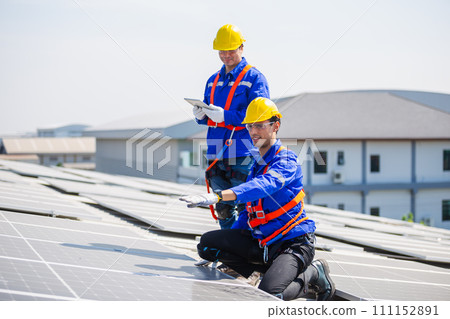 Technicians are installing and inspecting standards of solar panels on roof of an industrial. Technicians are installing and inspecting standards of solar panels on roof of an industrial. 111152891