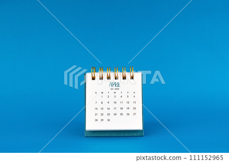 April 2024 mini desk calendar on blue background. 111152965