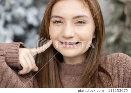 Close up portrait of face young caucasian beautiful woman blond hair smiling with braces Close up portrait of face young caucasian beautiful woman blond hair smiling with braces 111153675