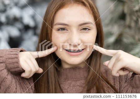 Close up portrait of face young caucasian beautiful woman blond hair smiling with braces Close up portrait of face young caucasian beautiful woman blond hair smiling with braces 111153676