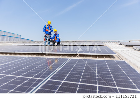 Technicians are installing and inspecting standards of solar panels on roof of an industrial. Technicians are installing and inspecting standards of solar panels on roof of an industrial. 111153721