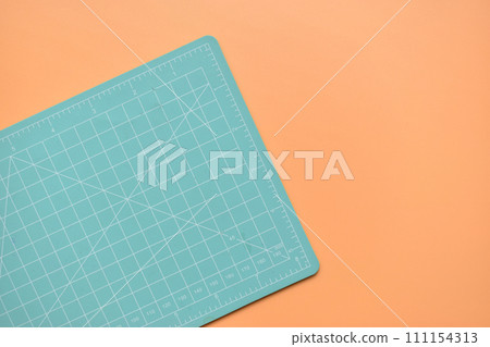 green cutting mat on orange background, object tool for design 111154313