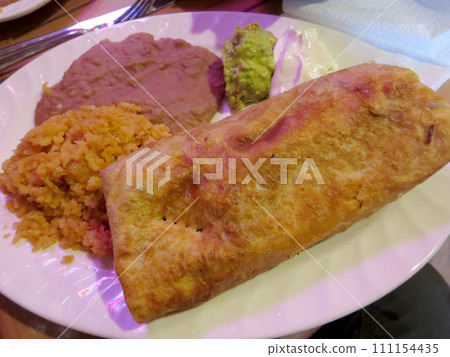 Chimichanga with spanish rice, beans, side guacamole, and sour cream Chimichanga with spanish rice, beans, side guacamole, and sour cream 111154435